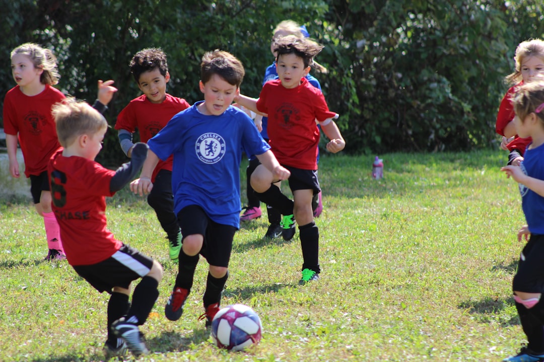 A youth soccer coach organizing a practice session with young players on a field, demonstrating drills and teamwork.