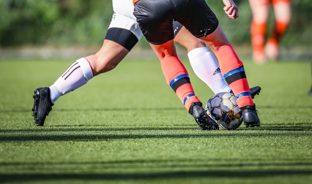 A young soccer player stretching on the field after practice, with a focus on recovery and relaxation.