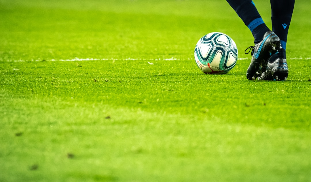 A player practicing soccer dribbling skills on a field, focusing on ball control and movement.