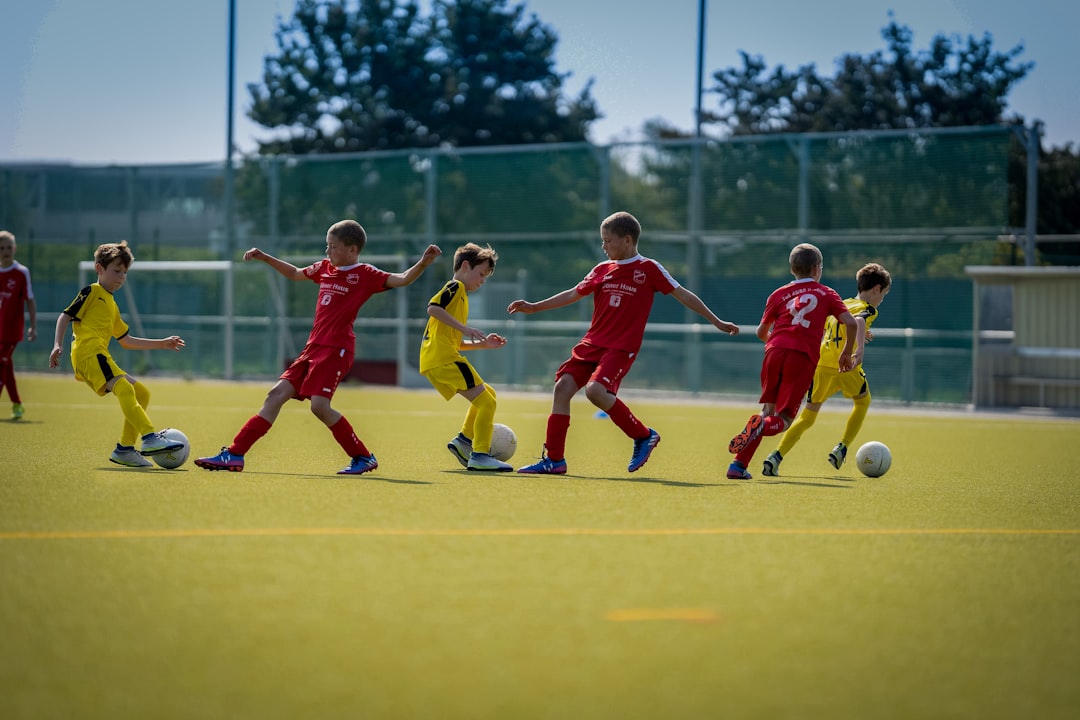 A group of young soccer players practicing passing drills on a grassy field, showcasing teamwork and skill development.
